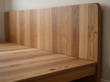 Close-up of a modular bedroom interior, warm timber veneer panel wall behind a low platform bed, north-facing diffused light, empty room, sharp material texture detail at edge of frame