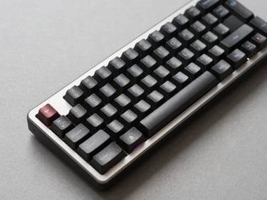 Close-up overhead studio shot of a mechanical gaming keyboard on a neutral gray surface, even shadowless lighting, showing key legends and aluminum frame detail clearly, no RGB glow