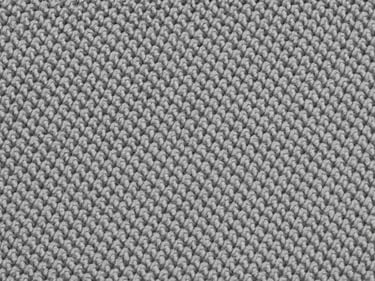 Macro flat-overhead close-up of polyester-spandex performance knit fabric under cool studio strobe, tight weave structure visible, neutral light grey surface, no garments