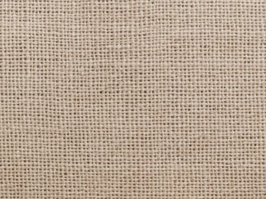 Macro flat-overhead close-up of cotton-linen natural blend fabric under cool north-facing daylight, open weave threads clearly visible, warm neutral tone, no garments