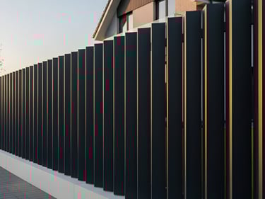 Valla metálica de lamas verticales en forma de V Modelo Vértice instalada en vivienda unifamiliar