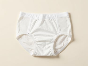 Studio photograph of unbranded adult incontinence brief, clean clinical layout, neutral cream background, soft shadows.