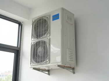 Ductless mini-split indoor air handler mounted high on a wall in a commercial office space, natural daylight from windows, clean wall surface, copper line-set running neatly to exterior