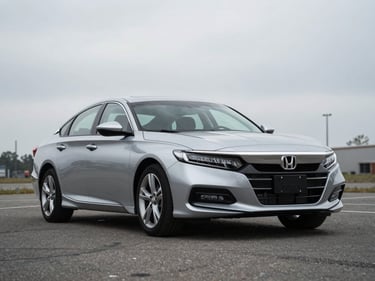 2021 Honda Accord sedan, silver, parked on an open lot under overcast light, three-quarter front view, documentary style