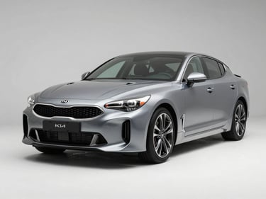 KIA Stinger sedan photographed in three-quarter front view under clean studio strobes on white floor, sharp metallic paint detail, no background distractions
