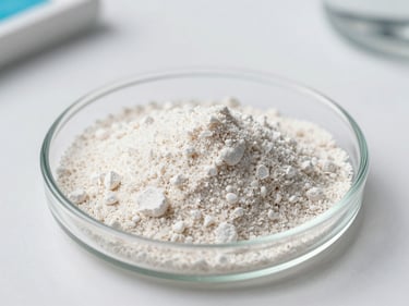 Macro photograph of firming lyophilized powder particles in a small glass dish on a white lab bench, cool white studio illumination, sharp crystalline texture, precise clinical framing
