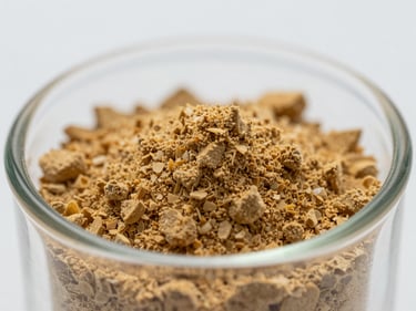 Macro close-up of fine lyophilized powder in a shallow glass vial, warm golden crystalline texture, cool even studio lighting on white background, clinical precision framing