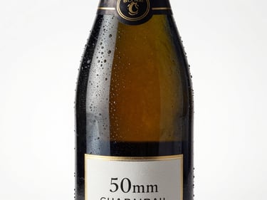 Crisp studio shot of a chilled champagne bottle with condensation, elegant label, bright and celebratory lighting.