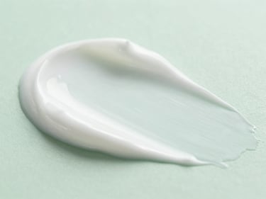 Macro close-up of white cosmetic cream texture, smooth waves, soft laboratory lighting, clean green tint