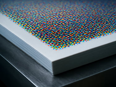 Extreme close-up of offset print sheet on press bed, ink halftone dots sharp and vivid under cool studio light, substrate edge visible