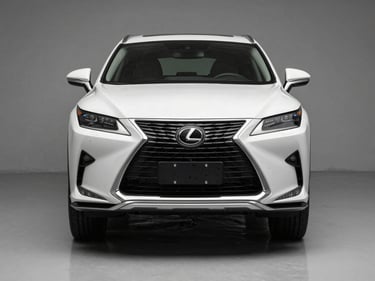 Head-on front angle of a white Lexus RX 350 on a clean grey studio floor, neutral-temperature studio lighting, badge and front fascia in sharp focus, no people