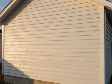 Wide shot of a South Shore home exterior freshly painted, warm afternoon light raking across the siding to show an even, clean finish, no scaffolding or equipment visible