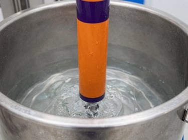 Image of a PET washing tank, stainless steel, water agitation, clean industrial setting, 35mm lens.