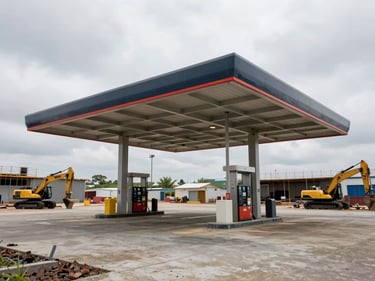 Wide environmental overcast shot, a fuel station canopy under active construction, structural steel frame of the canopy visible, pump island footings poured, open lot with construction equipment at mid-frame
