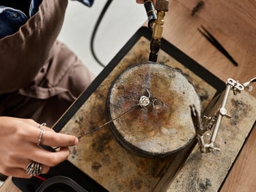 Un joyero utiliza un soplete para soldar un anillo de plata personalizado