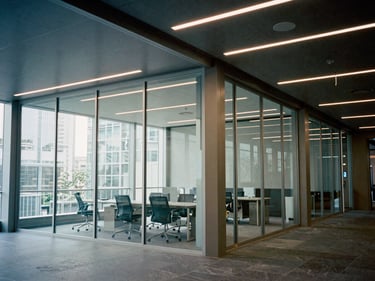 Modern commercial office interior with sharp geometric lighting and glass partitions, architectural film photography