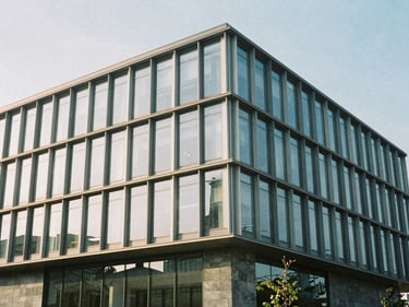 Exterior facade of a modern steel and glass commercial building under crisp morning daylight, sharp focus