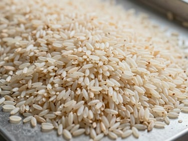 Overhead close-up of long-grain basmati rice spread across a flat sorting surface in a grading facility, natural daylight, cream-white grains showing length uniformity