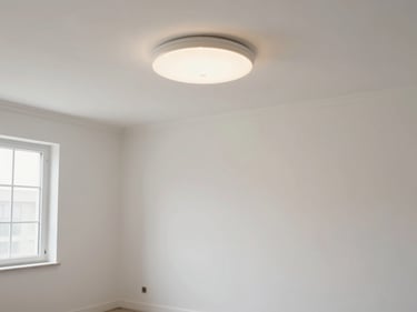 Wide environmental shot of a freshly painted room interior, new light fixture installed, clean baseboards and trim visible, daylight-neutral lighting through a window on the left