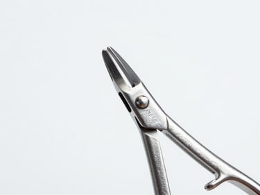 Close-up of a Mayo-Hegar needle holder's jaw mechanism, showing intricate detail and polished steel, cool studio lighting, sterile white background.