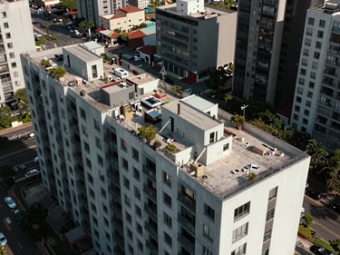 Aerial photograph of a completed multifamily residential complex in Mexico City, rooftop terraces and building footprint visible under flat natural light, no people, proof-of-delivery documentation