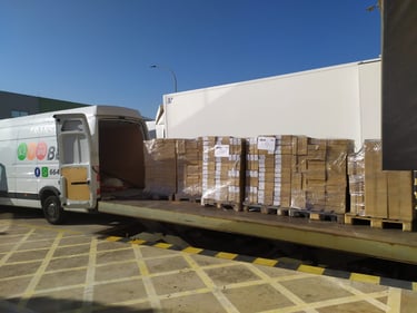 Furgoneta de Transportes Beal cargando pallets con mercancía en un muelle de carga.