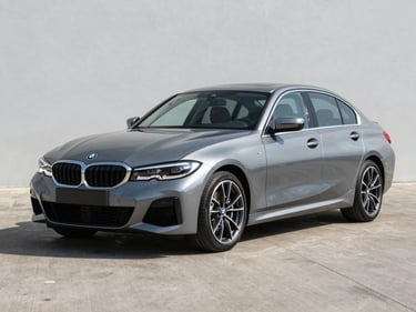 2021 BMW 3 Series grey sedan photographed three-quarter front on clean tarmac, bright daylight, no people, full vehicle clearly visible