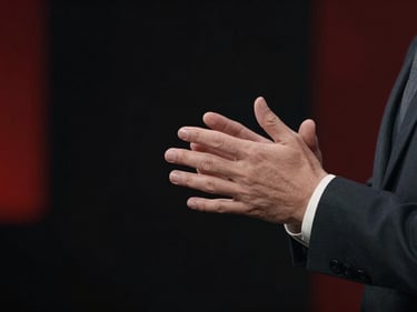 Elegant corporate video set, focused on a presenter's hands gesturing, soft studio lights, professional, cinematic, high-contrast.
