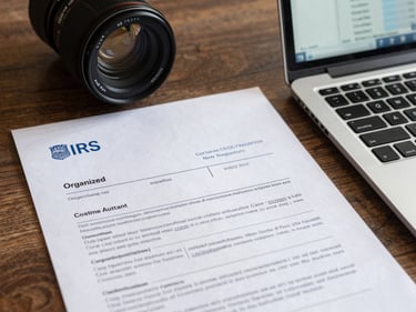 Organized desk with IRS correspondence letters and a laptop showing a resolution case tracker, clean overhead lighting