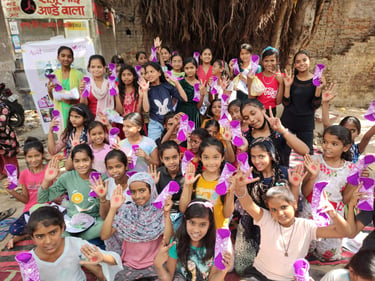 About thirty girls holding up their palms with red dots on.