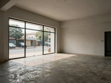 Wide-angle interior of a vacant retail shop unit on MG Road Vijayawada, clean concrete floor, large glass shopfront letting in natural daylight, neutral walls, no people