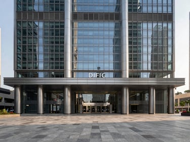 Wide architectural photograph of DIFC's Gate Building facade under sharp afternoon light, glass and steel geometry, empty pedestrian plaza in foreground, financial district context