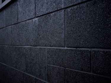 Masonry wall undergoing rising damp chemical injection, technical structural detail, low-key lighting.