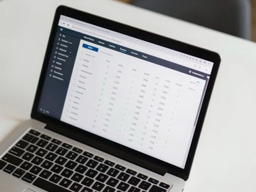Overhead view of a performance analytics interface on a laptop screen showing ROAS and CPM metrics, clean white desk surface, ambient studio light, numbers sharp and legible