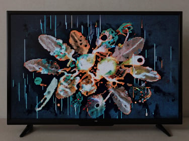 Close-up of a TV screen showing a cluster of dead pixels and vertical lines on an otherwise lit display, studio strobe lighting, sharp focus on the pixel fault, neutral background