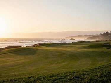 Serene view of the 18th hole at Pebble Beach at sunset, waves crashing softly against the cliffs, golden-hour light, 35mm