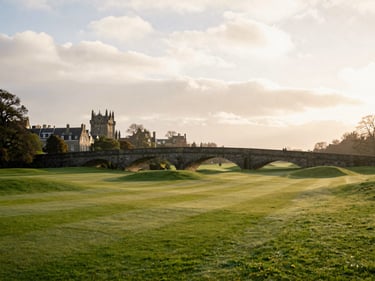 The Swilcan Bridge at St Andrews under a soft overcast Scottish sky, historic stone bridge, quiet fairways, 35mm