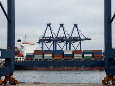 Container ship at a deep-water port, cargo cranes, global trade, cinematic, premium editorial photography, deep navy and steel tones, architectural framing, 35mm
