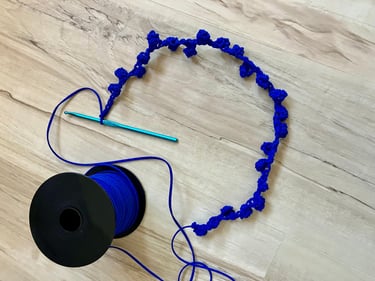 Royal blue cord crocheted into rosebuds with crochet hook