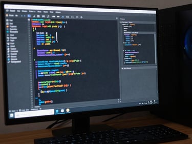 Modern computer setup with code and design tools visible on screen