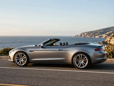 Luxury convertible parked on a coastal road during golden hour, sharp focus, premium editorial travel photography