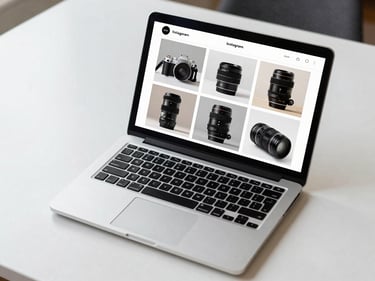 Overhead flat-lay of a laptop showing a luxury brand Instagram grid mockup, crisp daylight from upper left, clean white desk surface, grid of six editorial product images visible on screen, no people