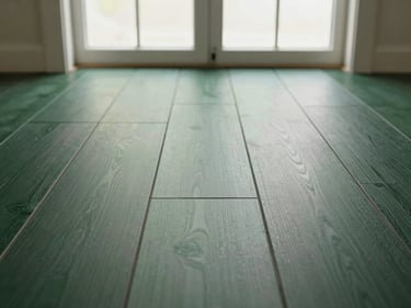 Straight-on clean shot of installed matte black vinyl flooring planks under bright natural window light, 35mm