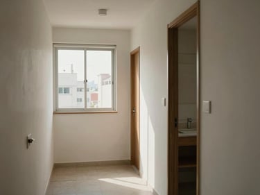 Interior of a compact São Paulo apartment, 1-bedroom, natural light through window, simple furnishings, clean finishes, residential corridor visible