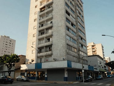 Exterior of a mid-rise residential building in São Paulo, ground-floor commercial street visible, bus stop nearby, morning light, documentary wide shot