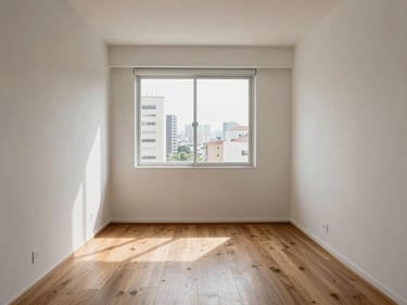 Interior of a compact studio apartment in São Paulo, natural morning light through a large window, light wood flooring, white walls, minimal furniture showing functional scale and clean finishes