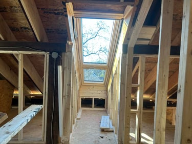 a lofted room with a skylight and a skylight