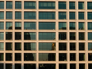 Modern commercial building facade with glass reflections, architectural symmetry, elegant lighting