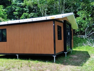 Maison préfabriquée reposant sur vis de fondation.