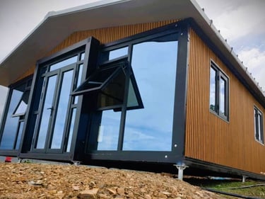 Maison modulaire moderne avec bardage bois et grandes baies vitrées.